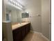Bathroom with a single sink vanity, large mirror, and tile flooring at 10303 Park Commons Dr, Orlando, FL 32832