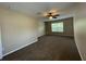 Spacious bedroom featuring neutral walls, carpet, a ceiling fan, and a well-lit window at 10303 Park Commons Dr, Orlando, FL 32832
