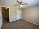 Comfortable carpeted bedroom features a ceiling fan, double closet, and neutral color scheme at 10303 Park Commons Dr, Orlando, FL 32832