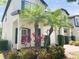 Beautiful home with a charming entryway and lush landscaping featuring colorful flowers and palm trees at 10303 Park Commons Dr, Orlando, FL 32832