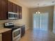Well-equipped kitchen has stainless steel appliances, dark cabinetry, and adjoining dining area at 10303 Park Commons Dr, Orlando, FL 32832
