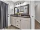 Bathroom with vanity and granite countertops, dual sinks, and decorative mirror and lighting at 10421 Mesa Ln, Clermont, FL 34711
