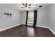 Bedroom featuring hardwood floors, a window with curtains, and a ceiling fan at 10421 Mesa Ln, Clermont, FL 34711