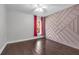 Neutral bedroom with eye catching geometric accent wall, window and hardwood floors at 10421 Mesa Ln, Clermont, FL 34711