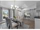 Open-concept dining room with elegant table, modern chandelier, and seamless entry to the home office at 10421 Mesa Ln, Clermont, FL 34711