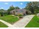 Traditional brick home with well-manicured lawn, long driveway, and lush landscaping at 10421 Mesa Ln, Clermont, FL 34711