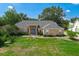 Charming brick home with a well-manicured lawn and inviting front entrance, surrounded by mature trees at 10421 Mesa Ln, Clermont, FL 34711