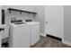 Laundry room equipped with modern washer and dryer units, sink, and storage shelf at 10421 Mesa Ln, Clermont, FL 34711