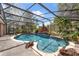 Inviting screened-in pool with a rock waterfall feature and lush tropical landscaping for relaxation at 10421 Mesa Ln, Clermont, FL 34711
