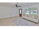 Bright living room featuring a ceiling fan, large window, and stylish area rug at 1110 Waterview E Blvd, Lakeland, FL 33801