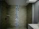 Bathroom featuring a beautifully tiled shower with decorative accents, a shower head, and storage at 1206 Skyview Cv, Lakeland, FL 33801