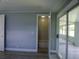 Bedroom featuring light gray walls, wood flooring, and a doorway leading to the bathroom at 1206 Skyview Cv, Lakeland, FL 33801