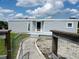 Home featuring gray siding, a walkway leading to the entrance, and rustic wooden and metal fencing at 1206 Skyview Cv, Lakeland, FL 33801
