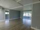 Open living room features light gray walls, wood flooring, and a sunroom with large windows at 1206 Skyview Cv, Lakeland, FL 33801
