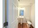 Clean, modern powder room with pedestal sink, toilet, and wood-look flooring at 222 Carpenters Way # 71, Lakeland, FL 33805