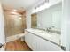 Modern bathroom featuring double sink vanity with granite top, large mirror, and tiled shower with glass door at 222 Carpenters Way # 71, Lakeland, FL 33805