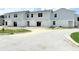 New two-story townhomes boast light gray siding and a white base with well-lit windows at 222 Carpenters Way # 71, Lakeland, FL 33805