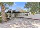 Well-maintained home featuring a side carport, white exterior with dark trim, and manicured landscaping at 2800 E Anderson St, Orlando, FL 32803
