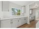 Bright kitchen featuring white cabinets, quartz countertops, and a view of trees outside the window at 2800 E Anderson St, Orlando, FL 32803