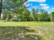 Home with expansive green backyard featuring mature trees and lush surroundings at 28712 Azalea Ave, Paisley, FL 32767