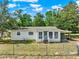 Front exterior showcasing the classic architecture and fenced yard, surrounded by lush foliage at 28712 Azalea Ave, Paisley, FL 32767