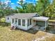 Charming single-story home with a carport, a screened-in porch, and mature trees at 28712 Azalea Ave, Paisley, FL 32767