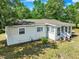 Exterior home view featuring the screened-in porch and siding, surrounded by mature landscaping at 28712 Azalea Ave, Paisley, FL 32767