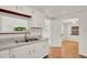 Kitchen featuring an undermount sink, white cabinets, and wood flooring at 28712 Azalea Ave, Paisley, FL 32767