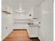Kitchen featuring white cabinets, a stainless steel sink, and hardwood flooring at 28712 Azalea Ave, Paisley, FL 32767