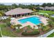 Aerial view of the community pool and clubhouse with lush landscaping, offering a resort-style living experience at 7991 Lake James Blvd, Lakeland, FL 33810