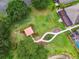 Aerial view of the backyard featuring a gazebo, shuffleboard court, beautiful landscaping, and a pond at 7991 Lake James Blvd, Lakeland, FL 33810