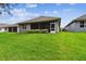 Lush backyard featuring a well-maintained lawn and a screened-in patio, perfect for outdoor entertaining and leisure at 7991 Lake James Blvd, Lakeland, FL 33810