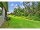 Expansive backyard with vibrant green lawn and view of mature trees providing shade and privacy at 7991 Lake James Blvd, Lakeland, FL 33810