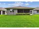 Well-maintained backyard featuring lush green grass and a screened-in patio for outdoor relaxation and entertaining at 7991 Lake James Blvd, Lakeland, FL 33810