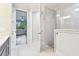 Bright bathroom featuring white marble floors, glass shower, and gray vanity, offering a modern and luxurious feel at 7991 Lake James Blvd, Lakeland, FL 33810