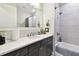 Bright bathroom featuring modern vanity with granite countertop, large mirror, and tiled shower and tub at 7991 Lake James Blvd, Lakeland, FL 33810