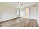 Well-lit bedroom with hardwood floors, modern ceiling fan, and doors leading to other rooms at 7991 Lake James Blvd, Lakeland, FL 33810