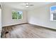 Spacious bedroom with hardwood floors, a modern ceiling fan, and bright windows with a treeline view at 7991 Lake James Blvd, Lakeland, FL 33810