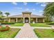 Beautiful clubhouse with a brick pathway, lush landscaping, and palm trees for community enjoyment and events at 7991 Lake James Blvd, Lakeland, FL 33810