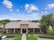 Charming clubhouse exterior featuring a brick entrance, manicured landscaping, and convenient parking at 7991 Lake James Blvd, Lakeland, FL 33810