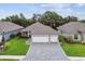 Charming home featuring a three-car garage and paved driveway, surrounded by manicured landscaping at 7991 Lake James Blvd, Lakeland, FL 33810