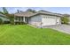 Charming home featuring a well-manicured lawn, a gray exterior, and a convenient two-car garage at 7991 Lake James Blvd, Lakeland, FL 33810
