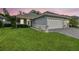 Charming home featuring a well-manicured lawn, a gray exterior, and a convenient two-car garage at 7991 Lake James Blvd, Lakeland, FL 33810