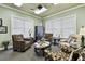 Inviting living room area featuring comfortable seating, a ceiling fan, and plenty of natural light from two large windows at 7991 Lake James Blvd, Lakeland, FL 33810