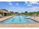 Gorgeous community pool showcasing clear blue water, brick trim, and lounge chairs for relaxation at 7991 Lake James Blvd, Lakeland, FL 33810