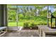 Charming screened porch overlooking a lush garden, providing a serene outdoor retreat with comfortable seating at 7991 Lake James Blvd, Lakeland, FL 33810