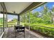 Inviting screened porch with a garden view, offering comfortable seating and a peaceful outdoor space for relaxation at 7991 Lake James Blvd, Lakeland, FL 33810