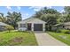 Charming single-story home with a well-maintained lawn, dark trim, and an attached garage at 9413 5Th Ave, Orlando, FL 32824
