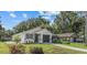 Exterior view of a one story home featuring dark trim, an attached garage, and a landscaped yard at 9413 5Th Ave, Orlando, FL 32824