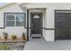 Close-up showcasing the front door, window, and garage door with dark trim at 9413 5Th Ave, Orlando, FL 32824